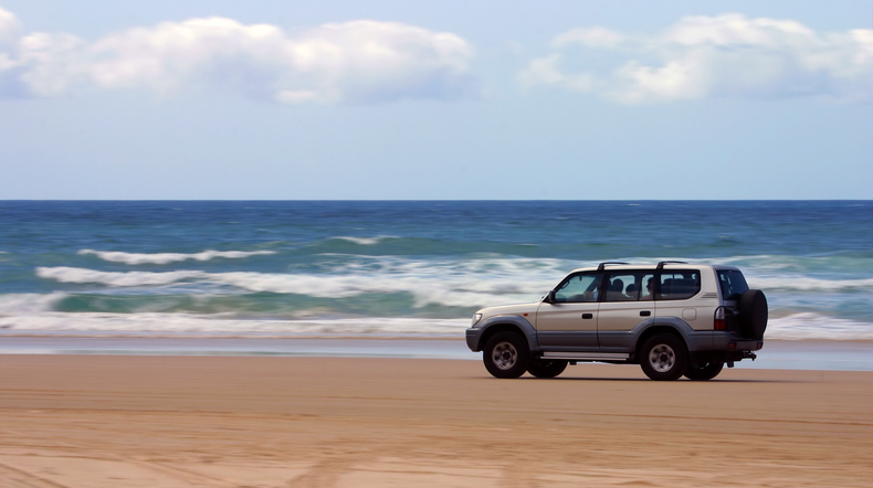 Four-wheel-drive SUV moving on a beach