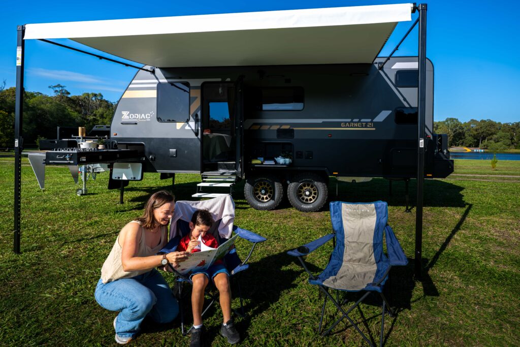 Mom and son camping outdoor with their Caravan